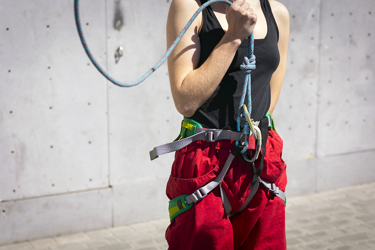 harness, rope, girl climbing up the wall